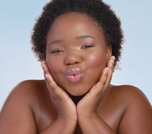 Image of model holding her face and doing a kissing motion