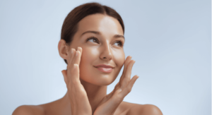A woman with her hands on her face, applying face cream thinking about urea in moisturizers vs. other ingredients