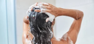 Woman washing her hair with Scalp Relief Shampoo & Conditioner