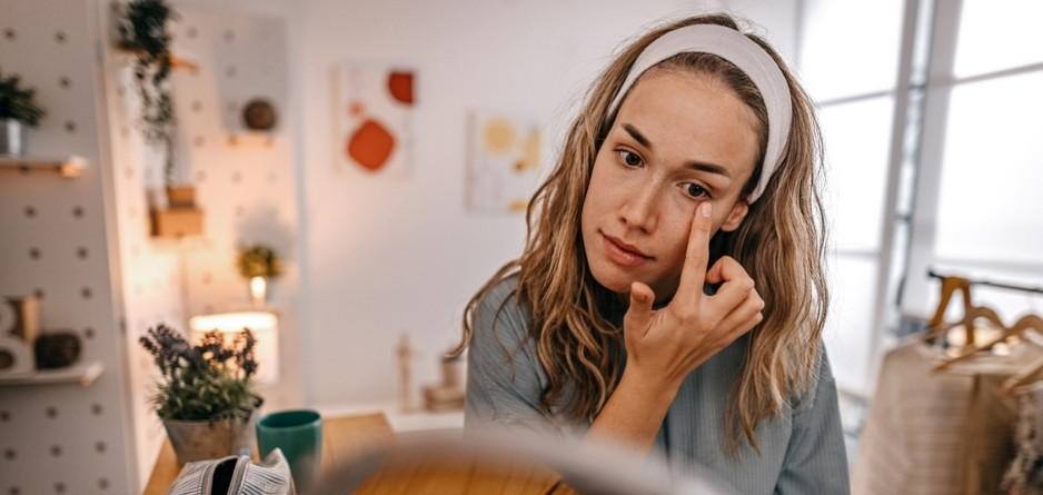 A woman applying eyelid eczema cream wondering about Ingredients to Use and Avoid Near the Eyes